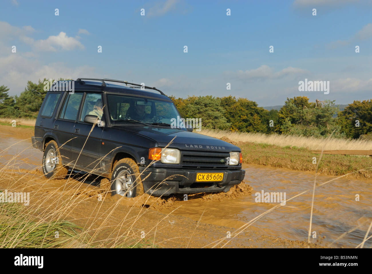 1990s Land Rover Discovery 1 crossing a flooded forest track. Stock Photo