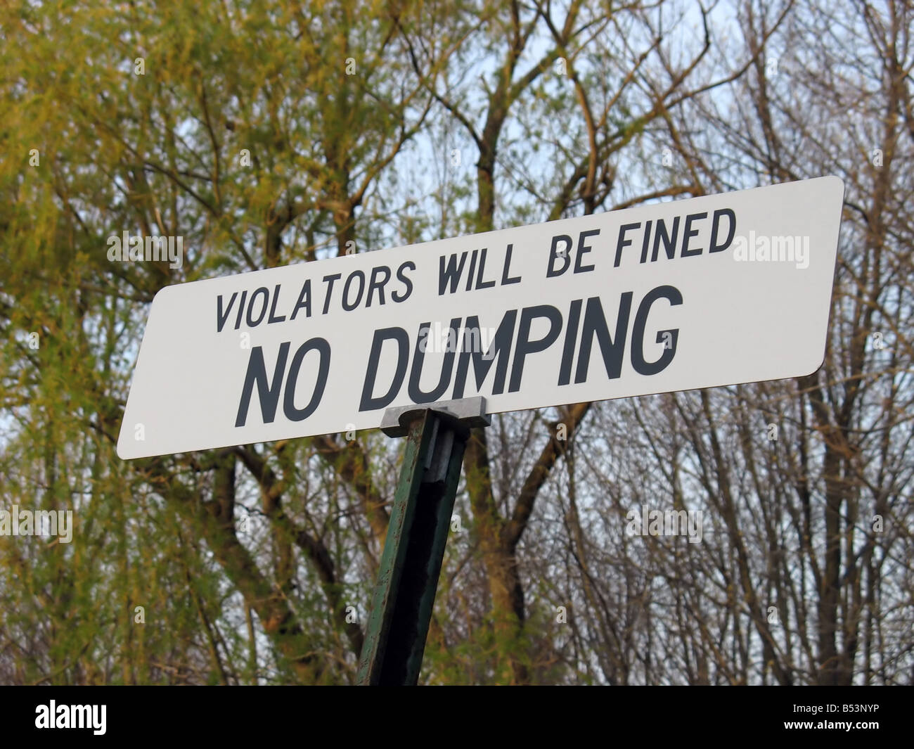 a no dumping sign - it states that violators will be fined Stock Photo