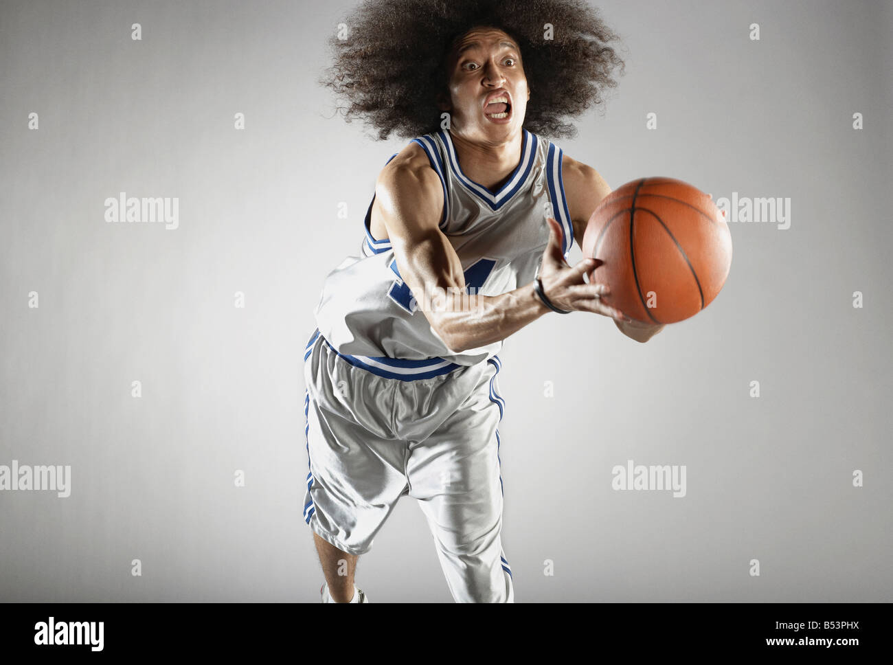 Mixed race basketball player holding basketball Stock Photo Alamy