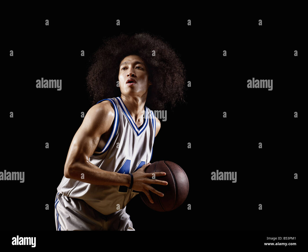 Mixed race basketball player holding basketball Stock Photo Alamy