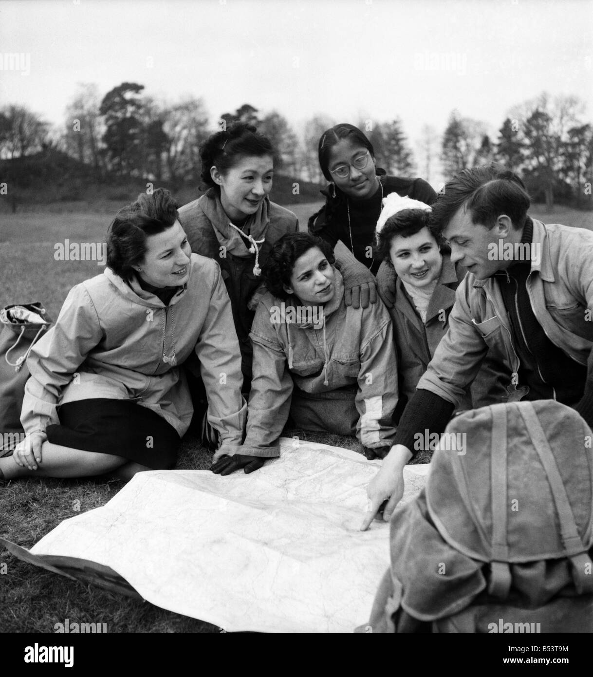 Which way is North?;Huguette Borrelly (France), Mrs. Yenawaki (Japan), Safia Hamly (Egypt), Raji Sundram (Malayan Indian), and Micky Ezri (Italy) are shown the route by scottish guide Tom Milroy before tackling the Bow Fell climb. April 1953 D1834 Stock Photo