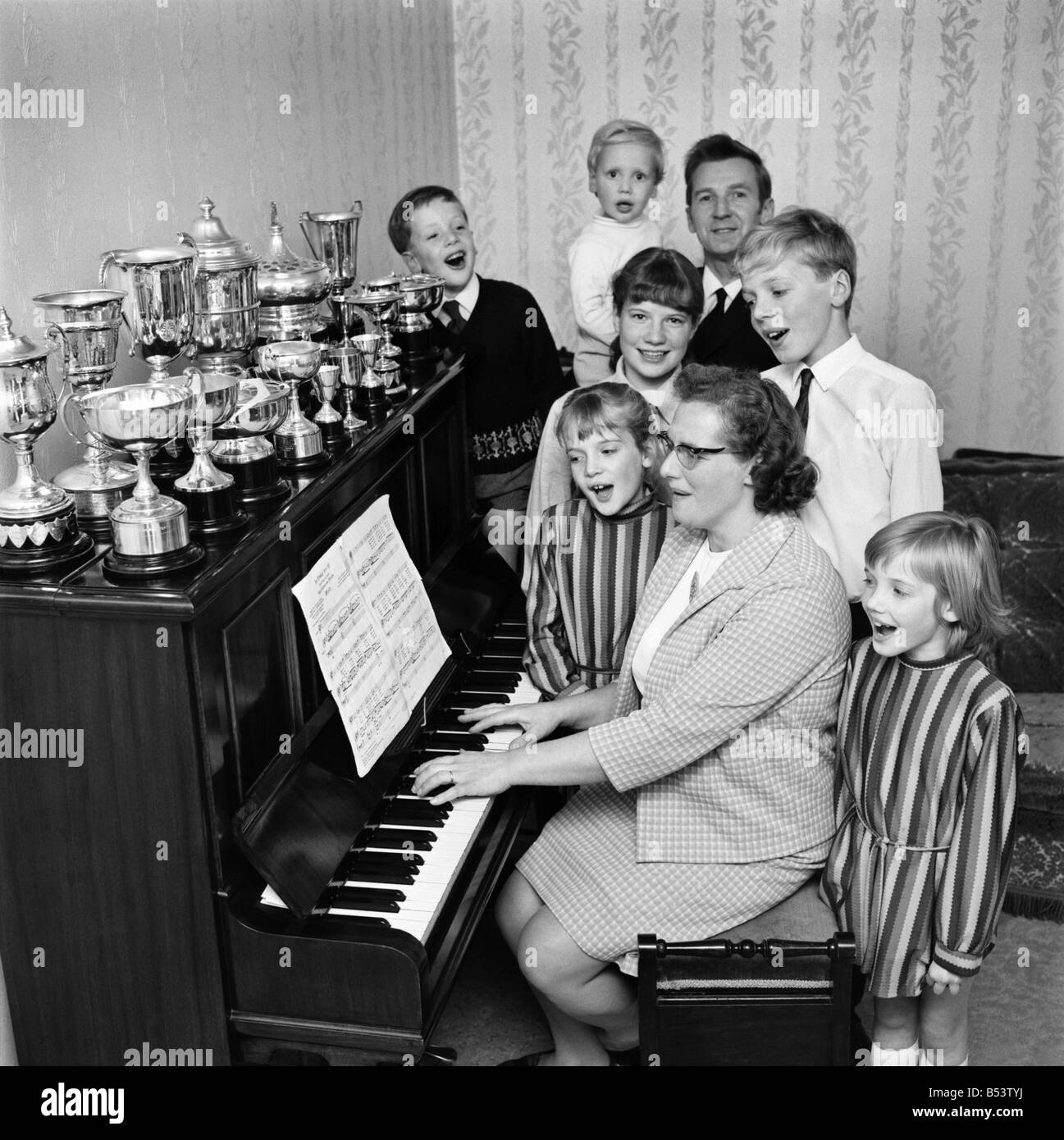 A family all gathered around the piano singing a song. November 1969  &#13;&#10;Z10653 Stock Photo - Alamy