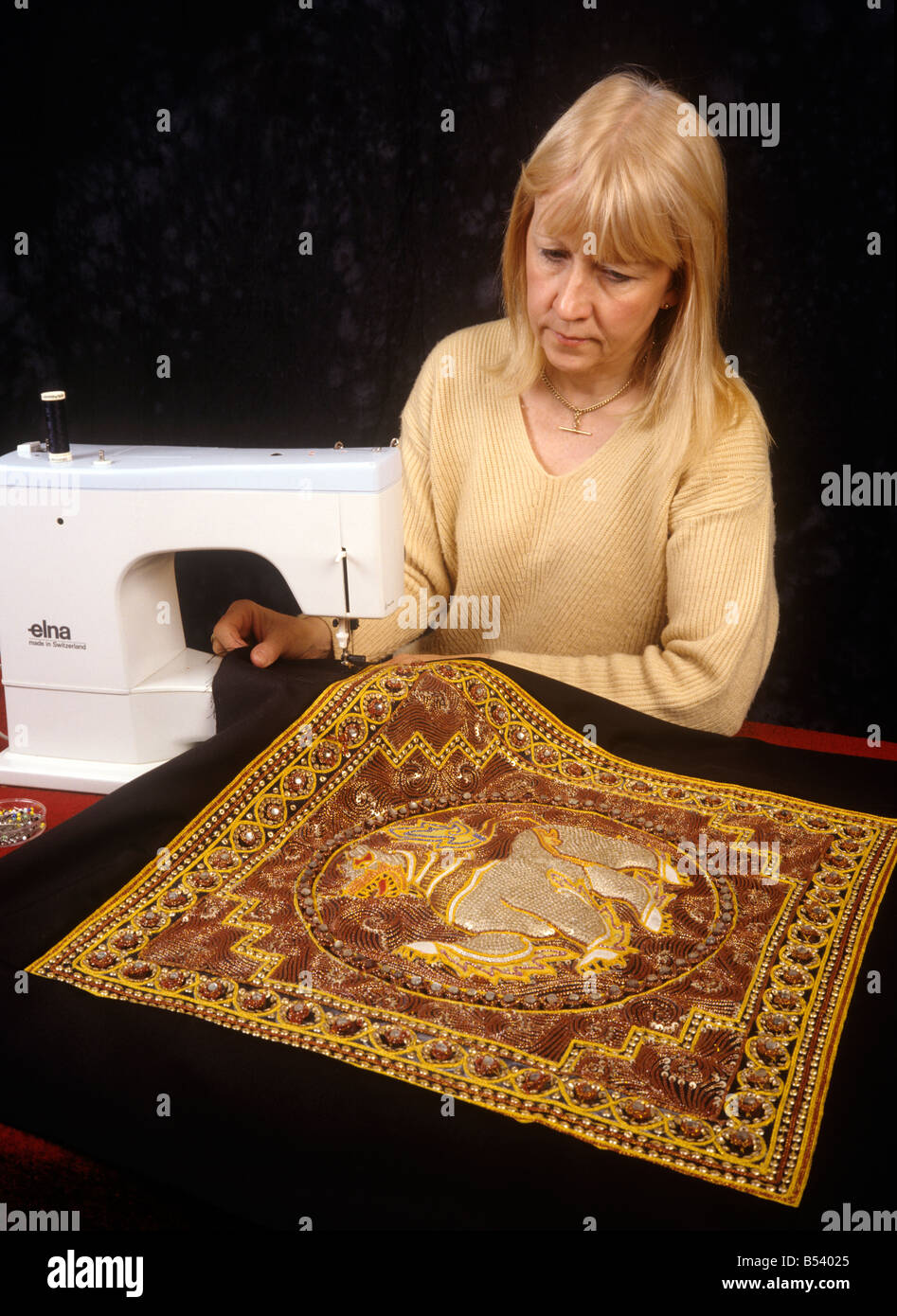 Crafts stretching a Burmese tapestry sewing a border on sewing machine