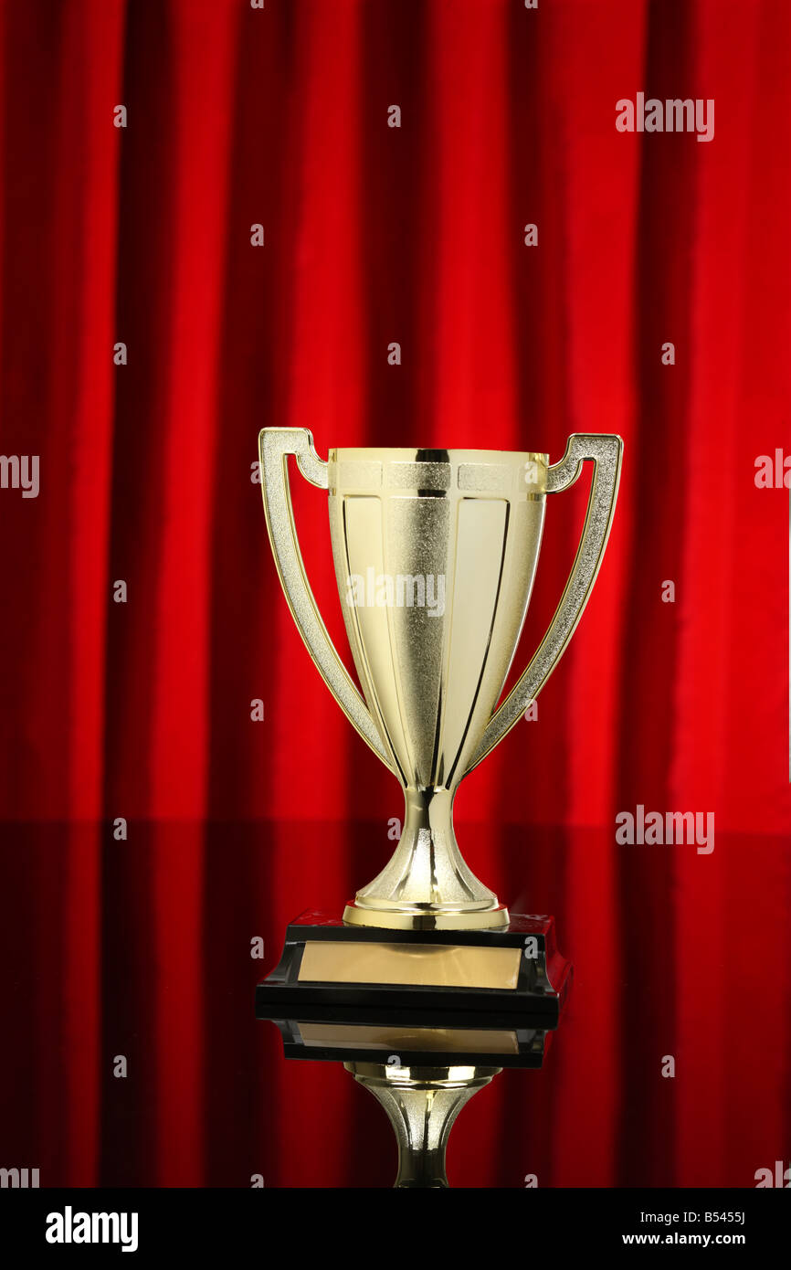 Gold cup trophy with red curtain background Stock Photo