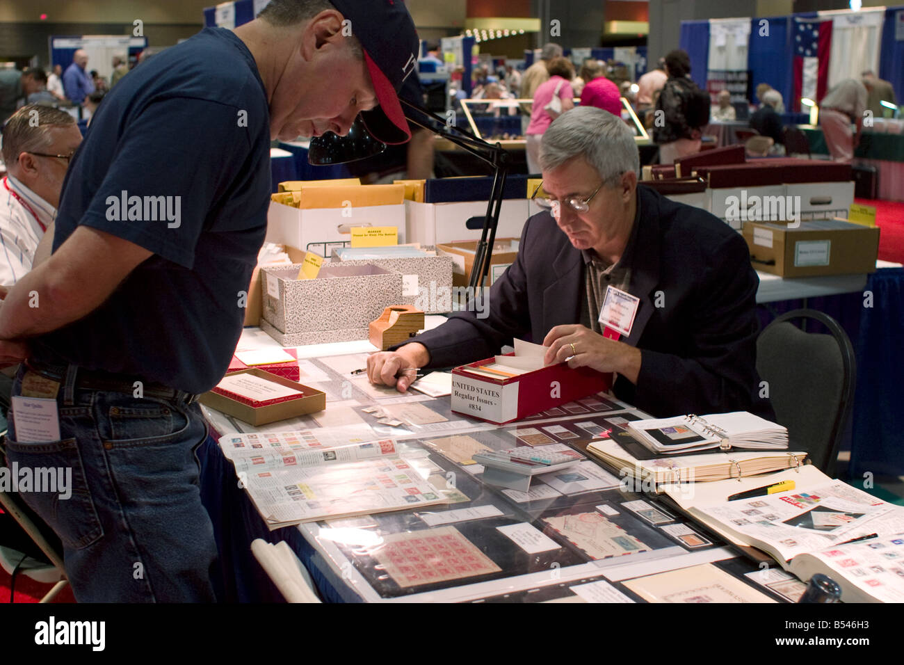 Stamp dealer offers stamps for sale at a booth at the American Philatelic Society stamp show in Hartford Connecticut Stock Photo