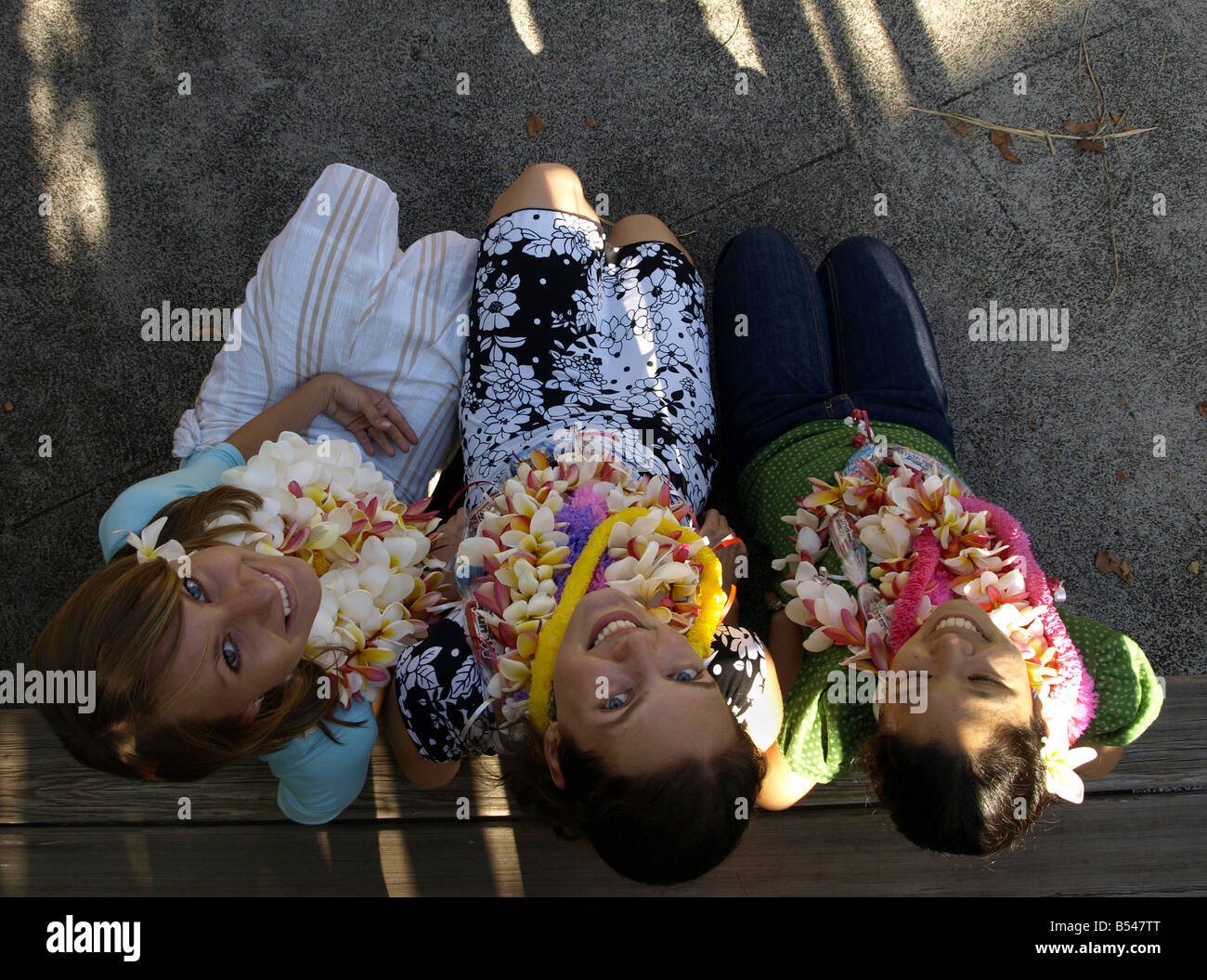 Girls with leis looking up Stock Photo