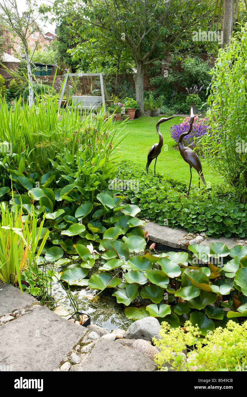 pool with water lilies and bird sculture Stock Photo