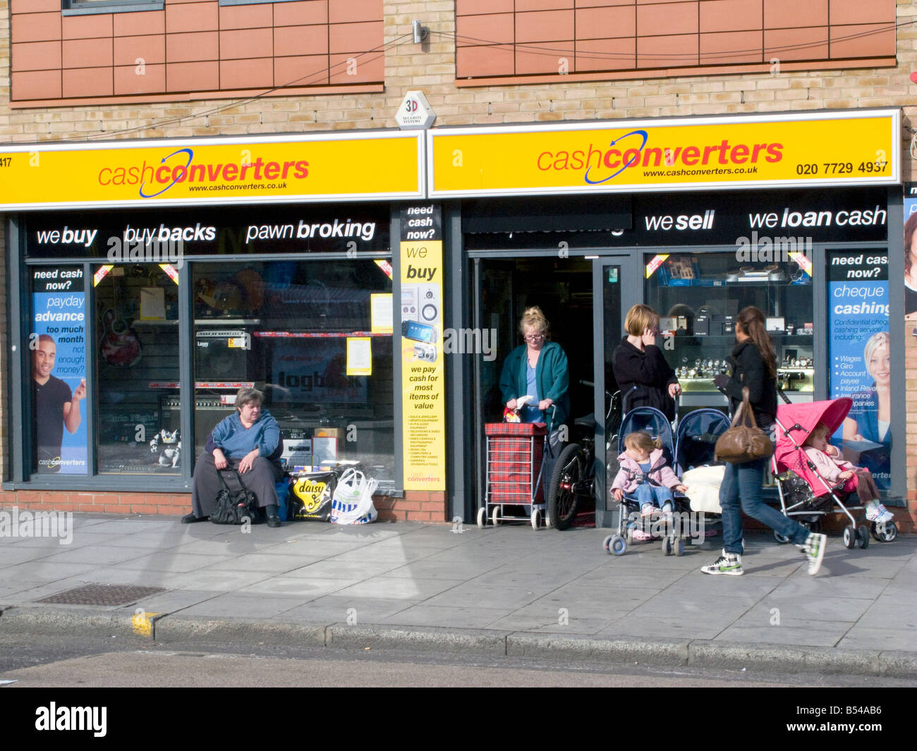 UK-Locals outside a pawn shop in Bethnal Green Rd, London.Photo © Julio Etchart Stock Photo