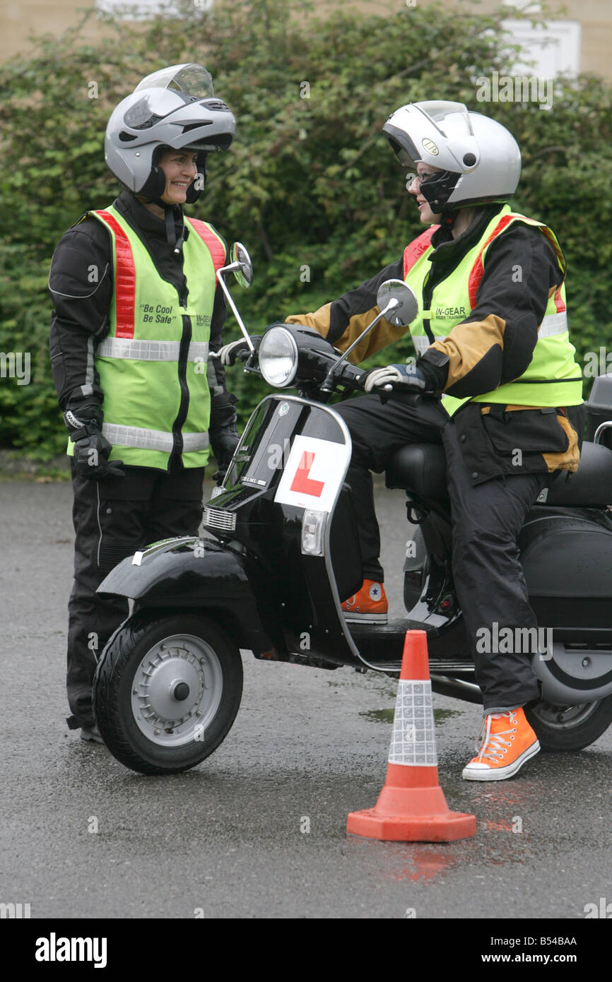 female learner motorcyclist during test talks to instructor. Stock Photo
