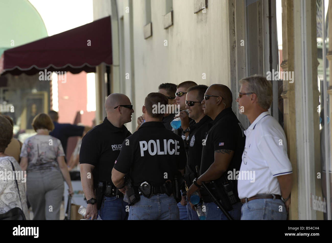 Law enforcement officers from the gang unit have a quick discussion as