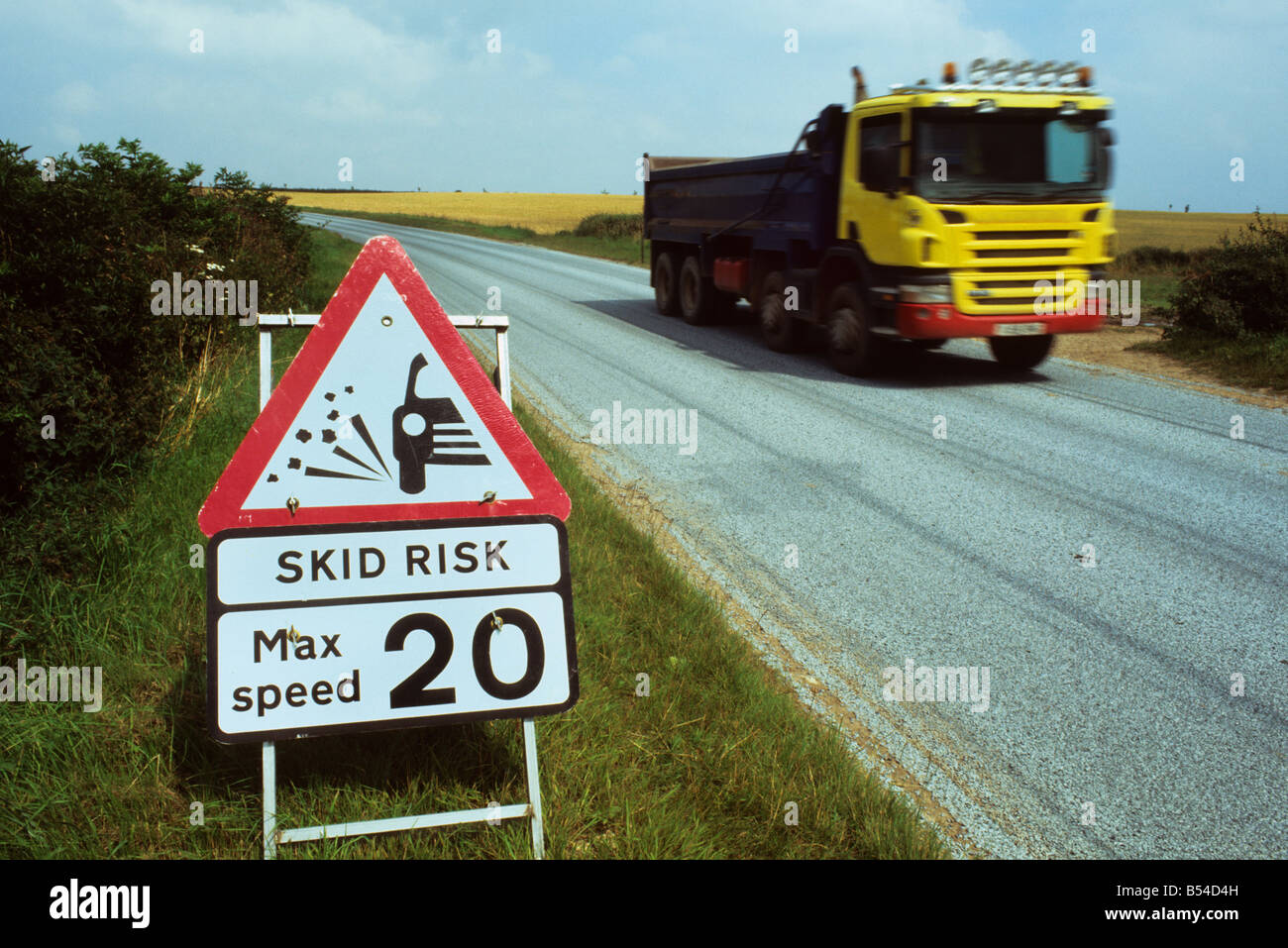 lorry passing warning sign of skid risk on newly resurfaced road near