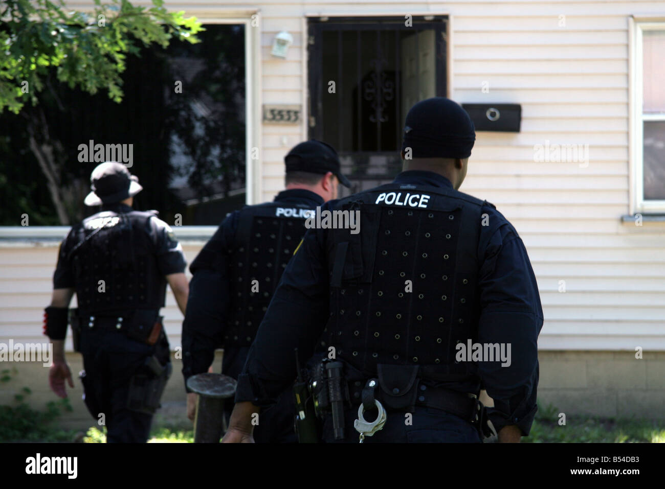 Police officers from the Detroit Narcs approach a house suspected of dealing drugs Stock Photo