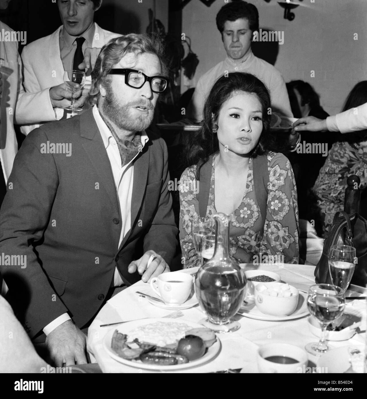 Photographer David Bailey today held a party in a Kings Road chelsea club to launch his book attended the party. Michael Caine with his girl friend Minda Feliciano. November 1969 Z10810-004 Stock Photo