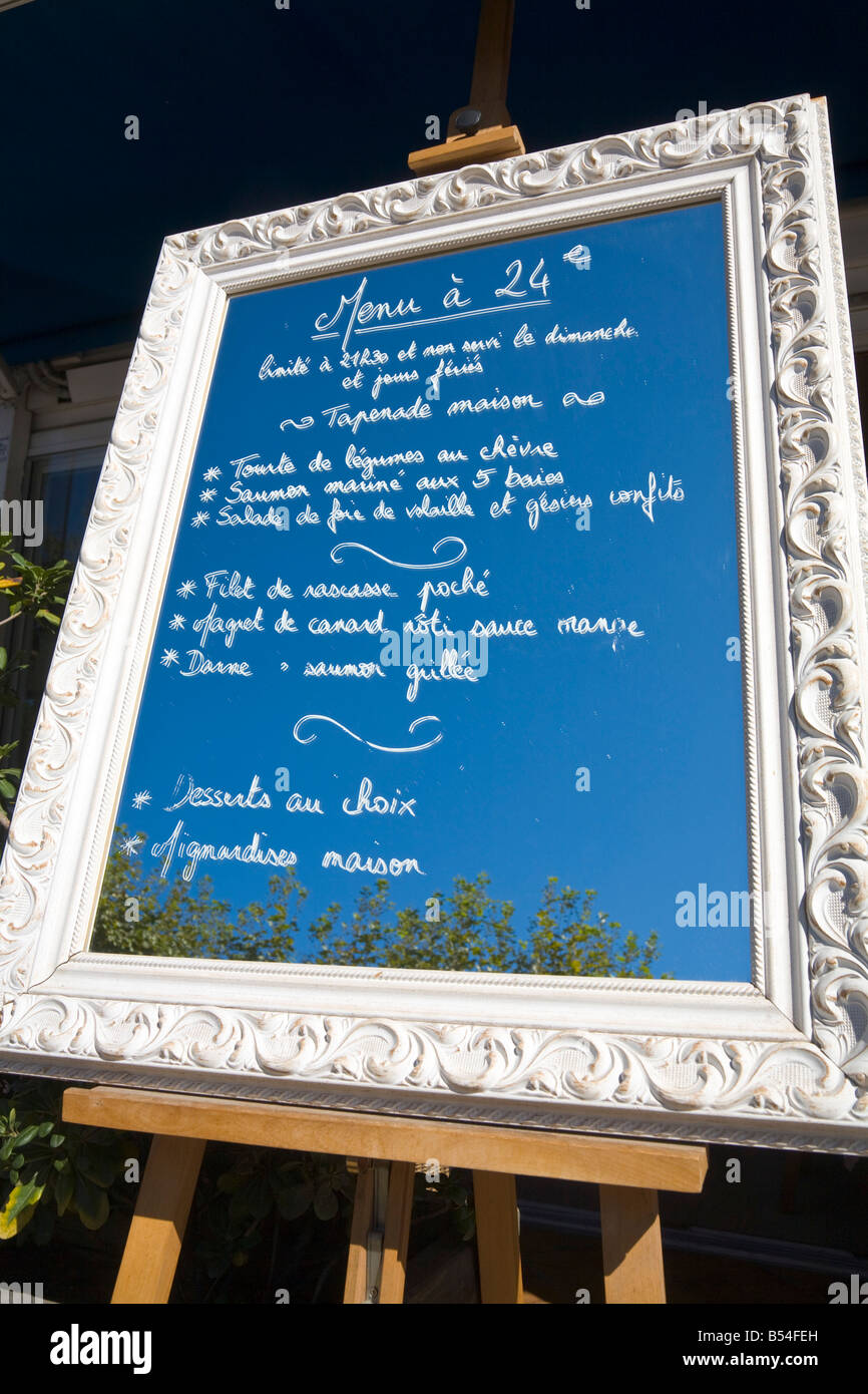 The menu of a restaurant is written on a mirror which reflects the blue sky of the Cote d'Azur / Provence Stock Photo