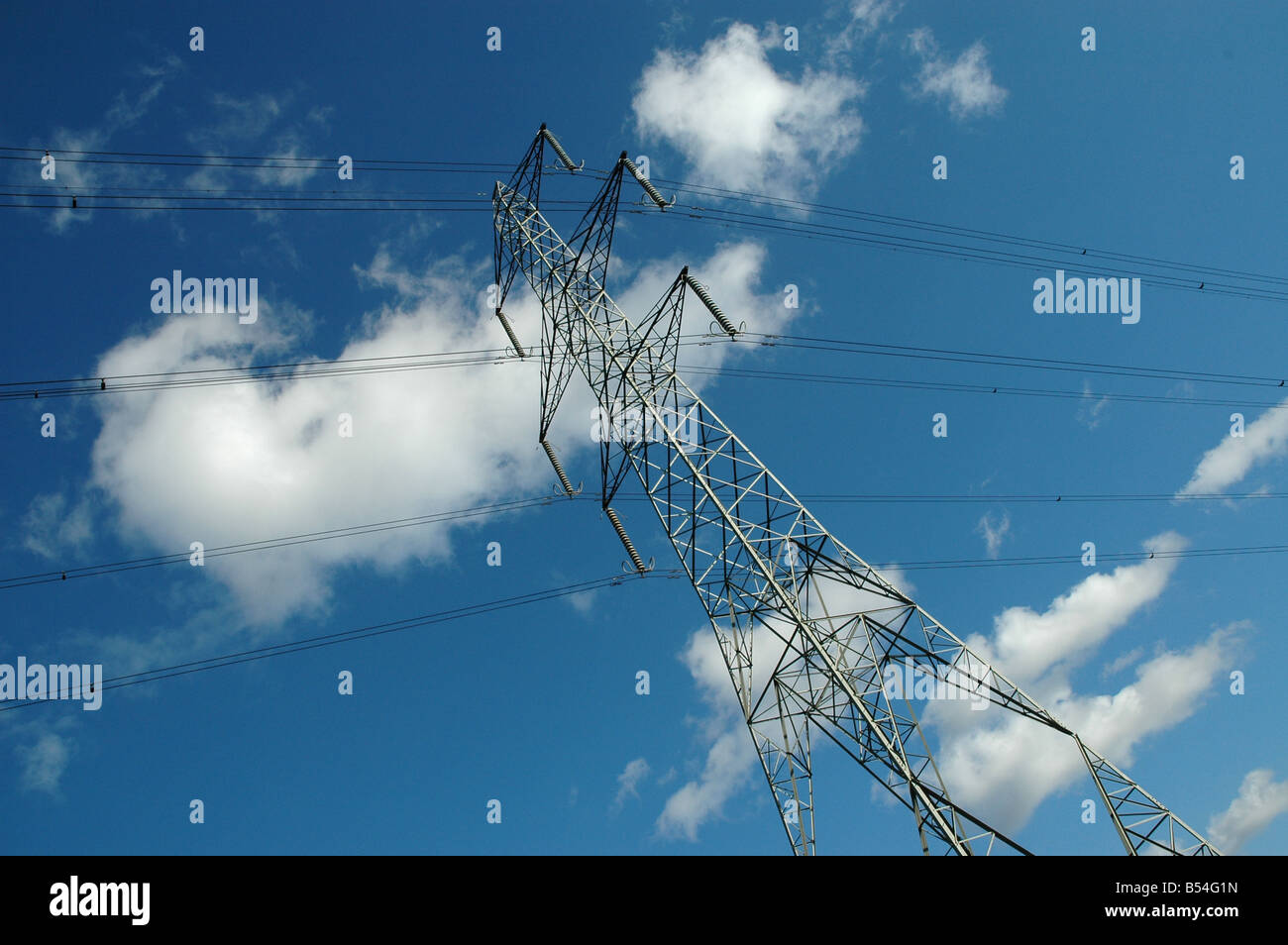 An electricity pylon with blue sky above Stock Photo - Alamy