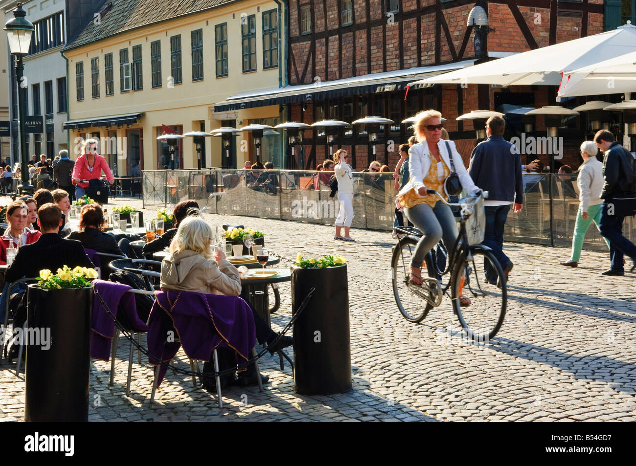 Cyclist passing pavement cafe in the Old Town of Malmö Sweden Stock Photo