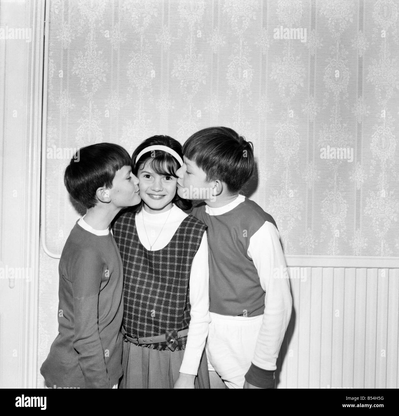Young Girl Gets A Kiss On Each Cheek From Two Boys October 1969 Stock Photo Alamy
