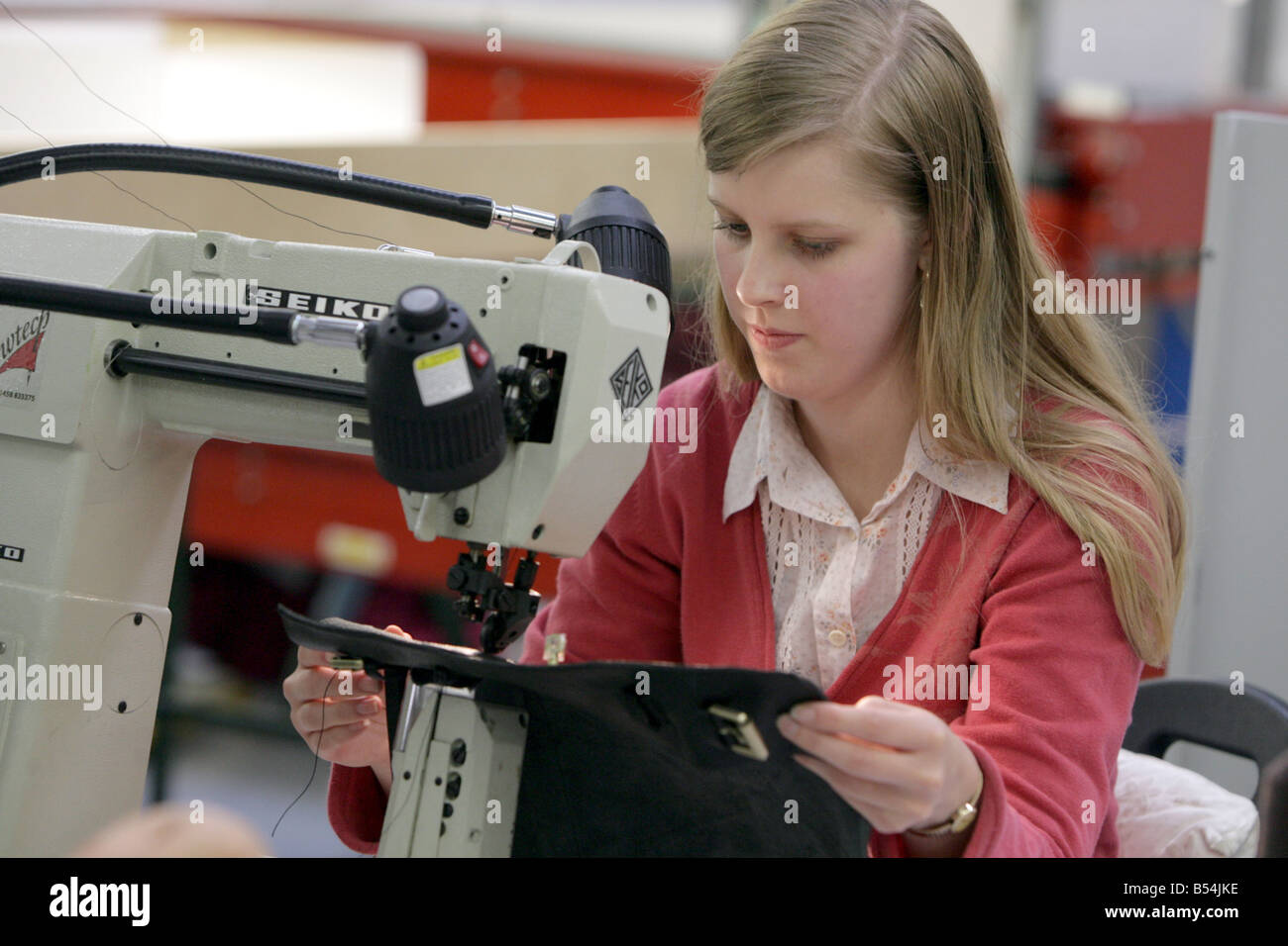female sewing machine worker in a leather handbag factory. Stock Photo