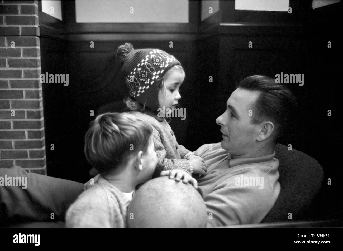 Sport: Football: Derby manager Brian Clough ponders the league cup draw the morning after his team's success at the baseball ground against Crystal Palace. Brian Clough with his two year old daughter Elizabeth watched by his son. October 1969 Z10423-001 Stock Photo