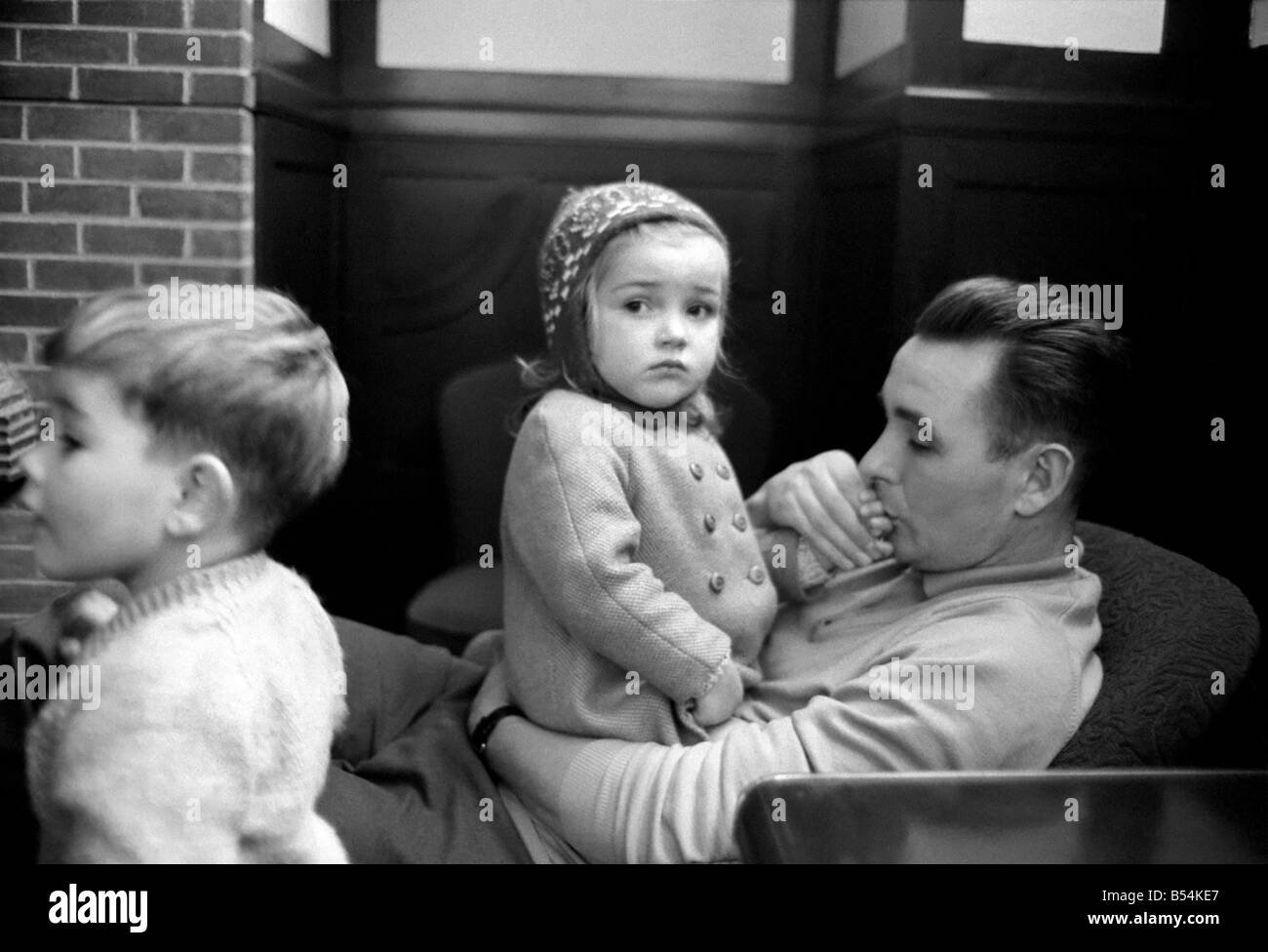 Sport: Football: Derby manager Brian Clough ponders the league cup draw the morning after his team's success at the baseball ground against Crystal Palace. Brian Clough with his two year old daughter Elizabeth watched by his son. October 1969 Z10423-004 Stock Photo
