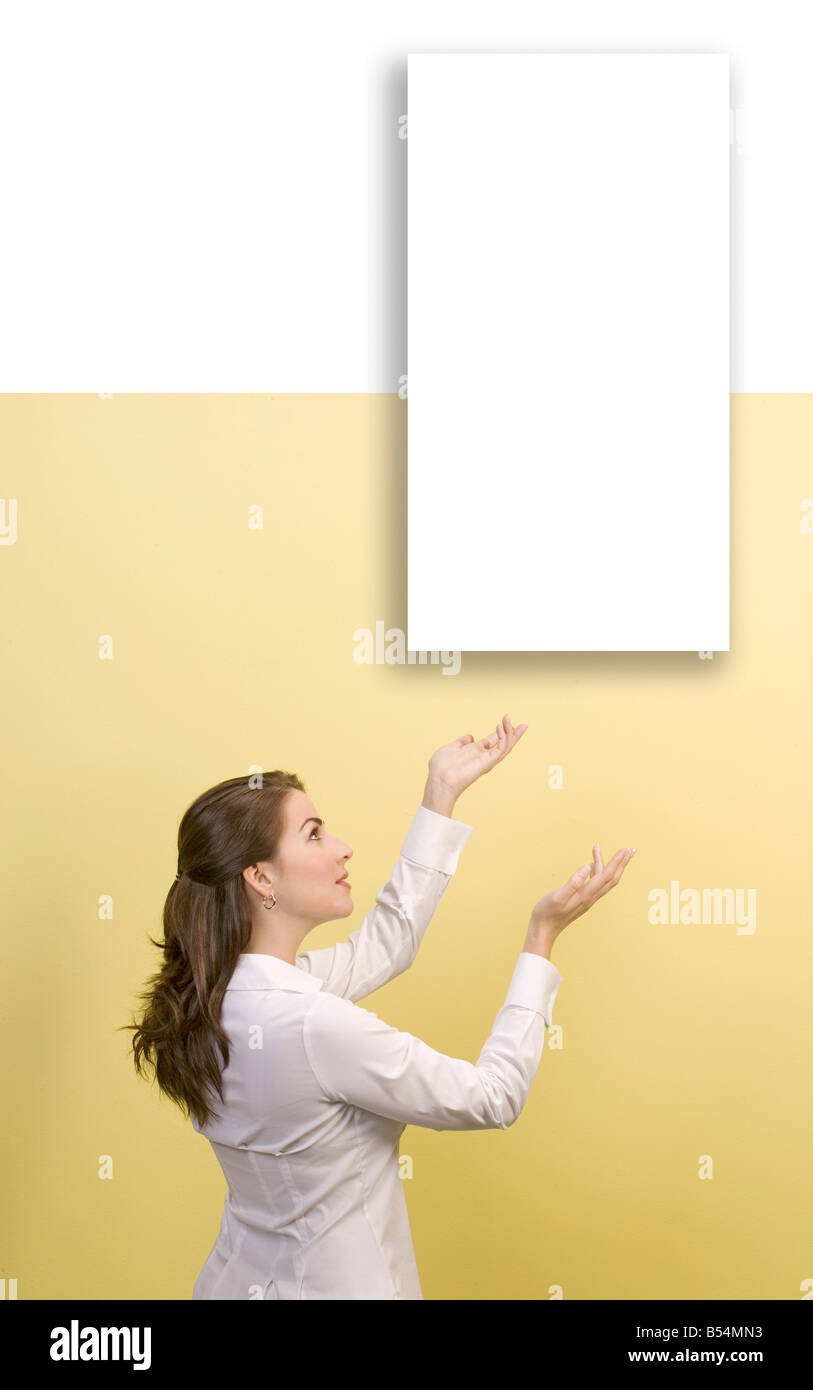 woman shows empty white picture on wall Stock Photo