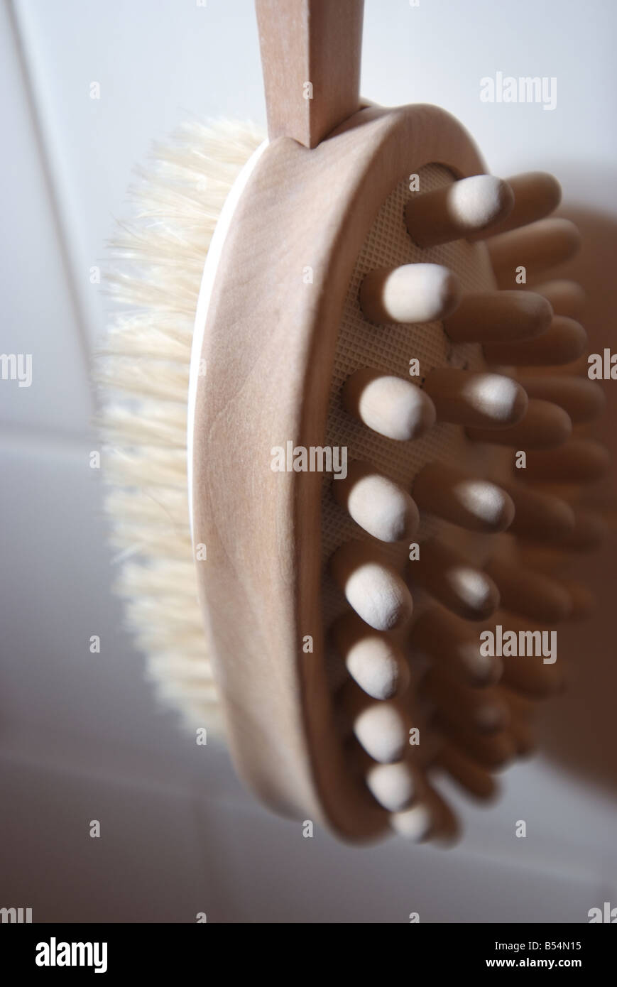 Bath brush hanging on a white tile shower wall Stock Photo