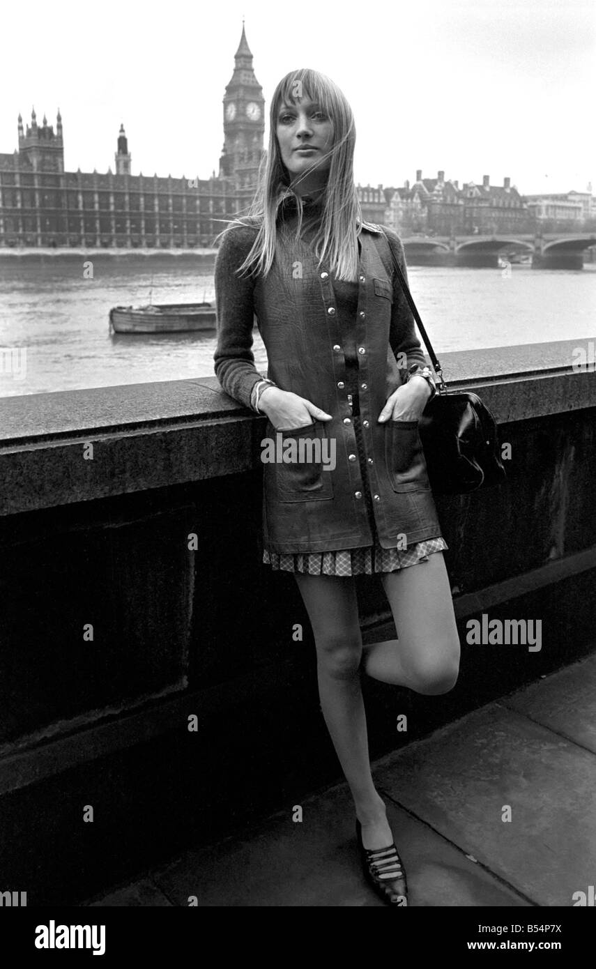 Places , London, England. A woman standing on the bank of the river Thames with the Houses of Parliament behind. November 1969 Stock Photo