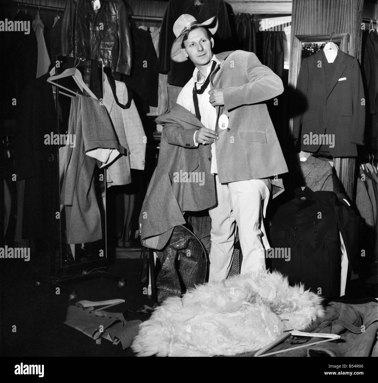 Fashion Clothing Humour. Young male model David Kempton from East Croydon, started work today at the new Young male menswear boutique in Kensington Church Street. His presents there could make the pre-Christmas customers look more than once at him, in fact if they stay long enough they could see him wearing 288 different outfits, for David will be on a marothon clothes change untill Thursday, making six changes an hour, day and night, to set up a new world record for Clothes Changing. David Kempton at the 'Take 6' making a hurried change. December 1969 Z11607-001 Stock Photo