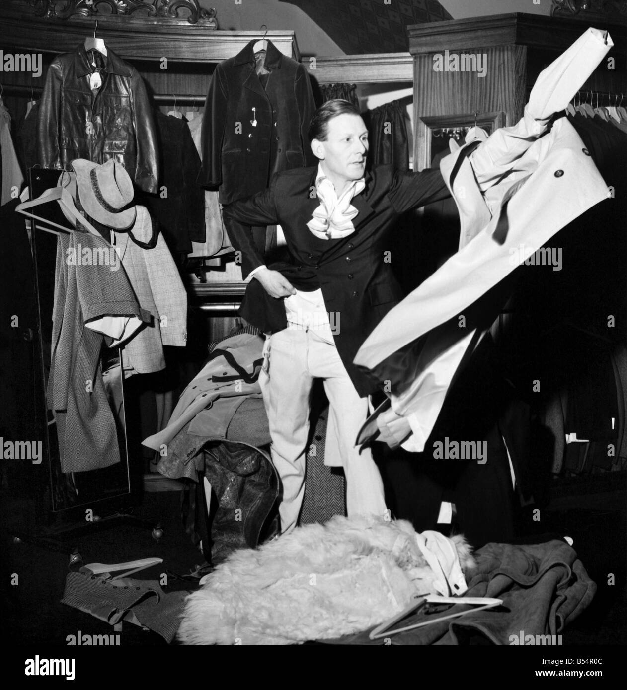 Fashion Clothing Humour. Young male model David Kempton from East Croydon, started work today at the new Young male menswear boutique in Kensington Church Street. His presents there could make the pre-Christmas customers look more than once at him, in fact if they stay long enough they could see him wearing 288 different outfits, for David will be on a marothon clothes change untill Thursday, making six changes an hour, day and night, to set up a new world record for Clothes Changing. David Kempton at the 'Take 6' making a hurried change. December 1969 Z11607-004 Stock Photo