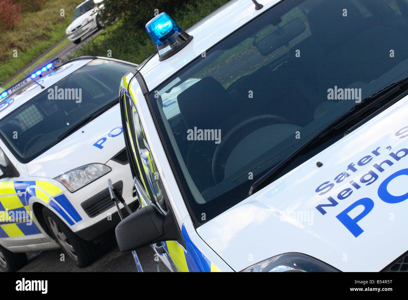 Two police cars parked as a road block with flashing blue light across