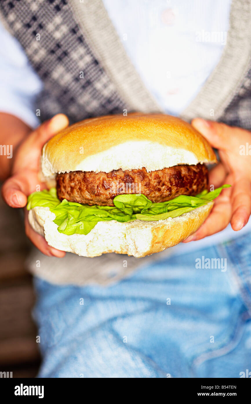 Close-up of Little boy holding a beef burger in his hands Stock Photo