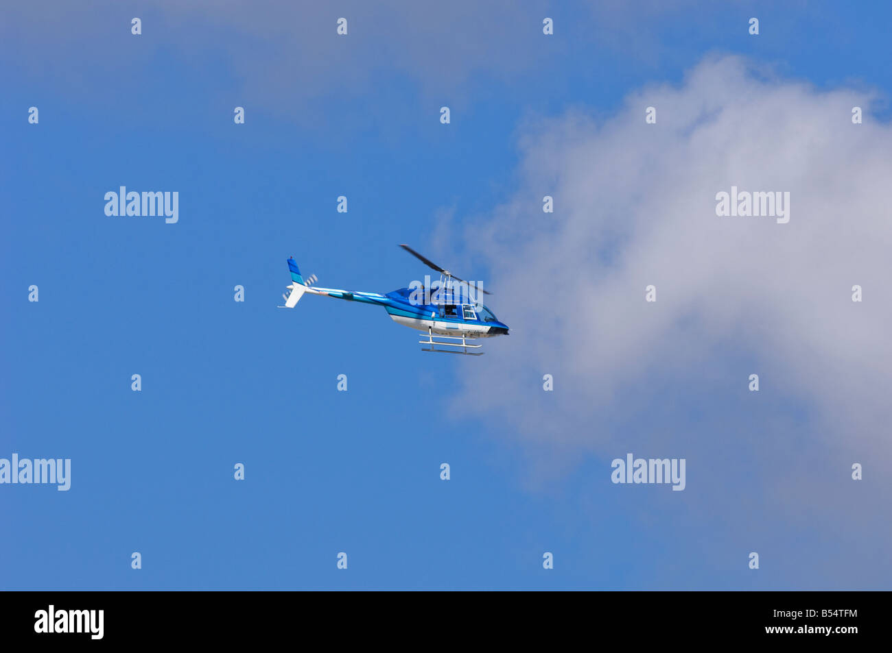 A blue helicopter in flight with a blue sky in Winnipeg, Manitoba, Canada. Stock Photo