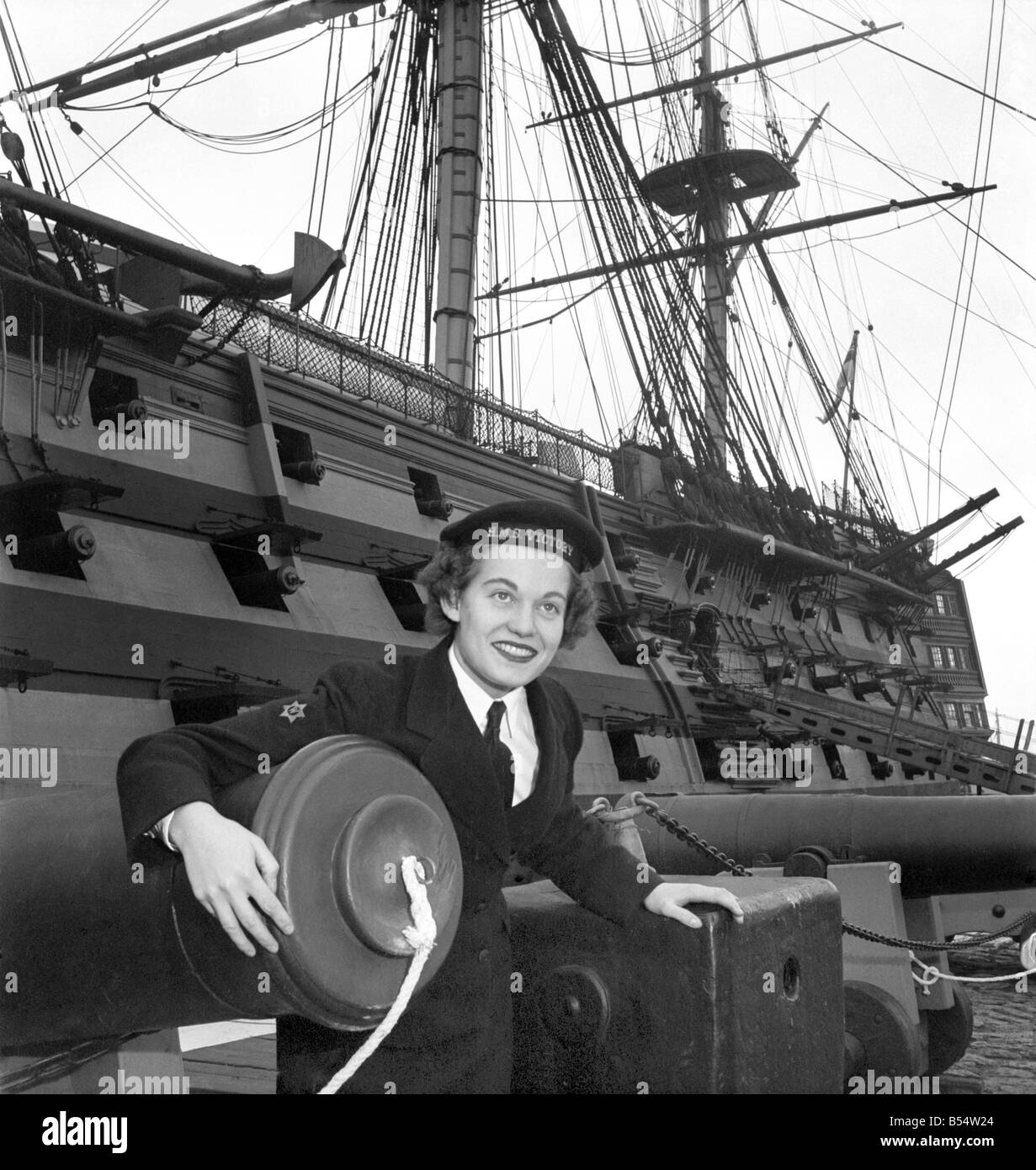 Royal Navy HMS Victory: WREN Margaret Mann 19 a winter in the navy, and Wren Joan Wallen age 20 of Radar Dept. They are intersted in a rum measure used aboard. The victory in Nelson days. October 1953 D6153 Stock Photo