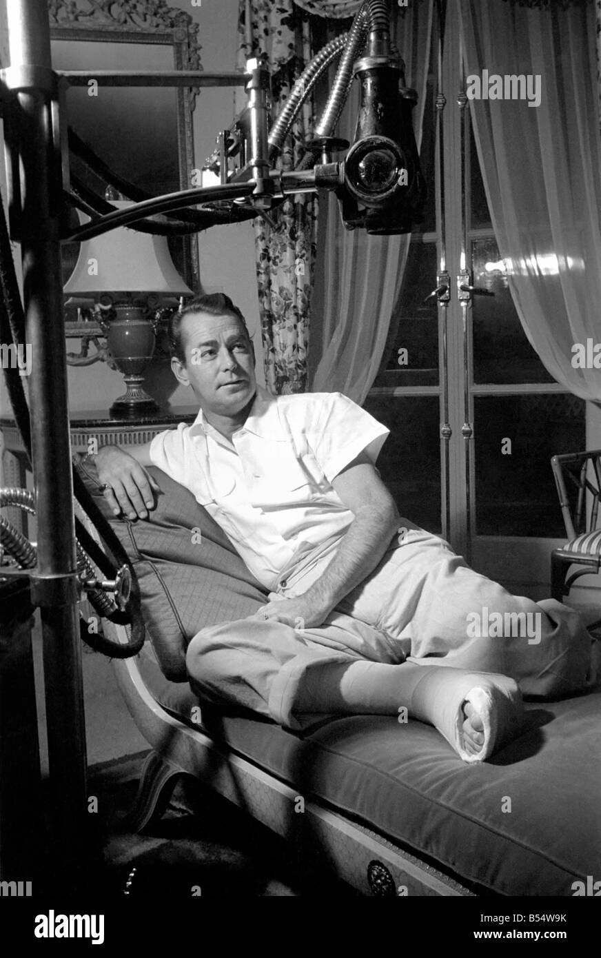 Film star Alan Ladd, who has injured his foot. October 1953 D6473-001 Stock Photo