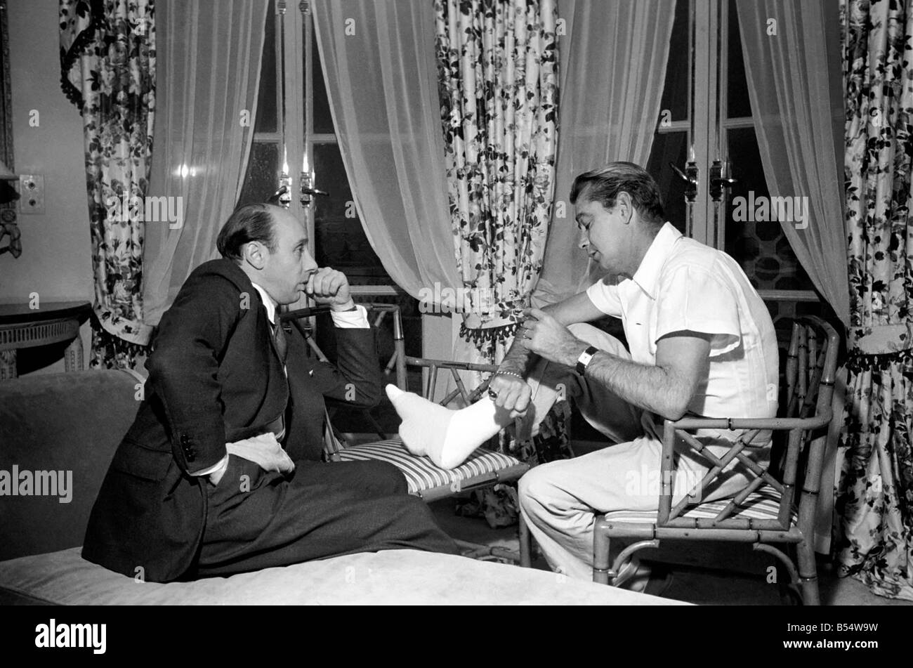 Donald Zec with film star Alan Ladd, who has injured his foot. October 1953 D6473-003 Stock Photo