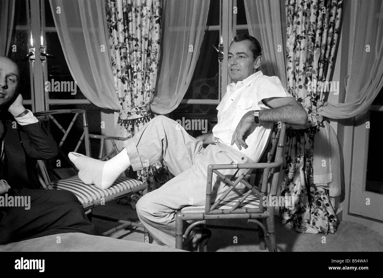 Donald Zec with film star Alan Ladd, who has injured his foot. October 1953 D6473 Stock Photo