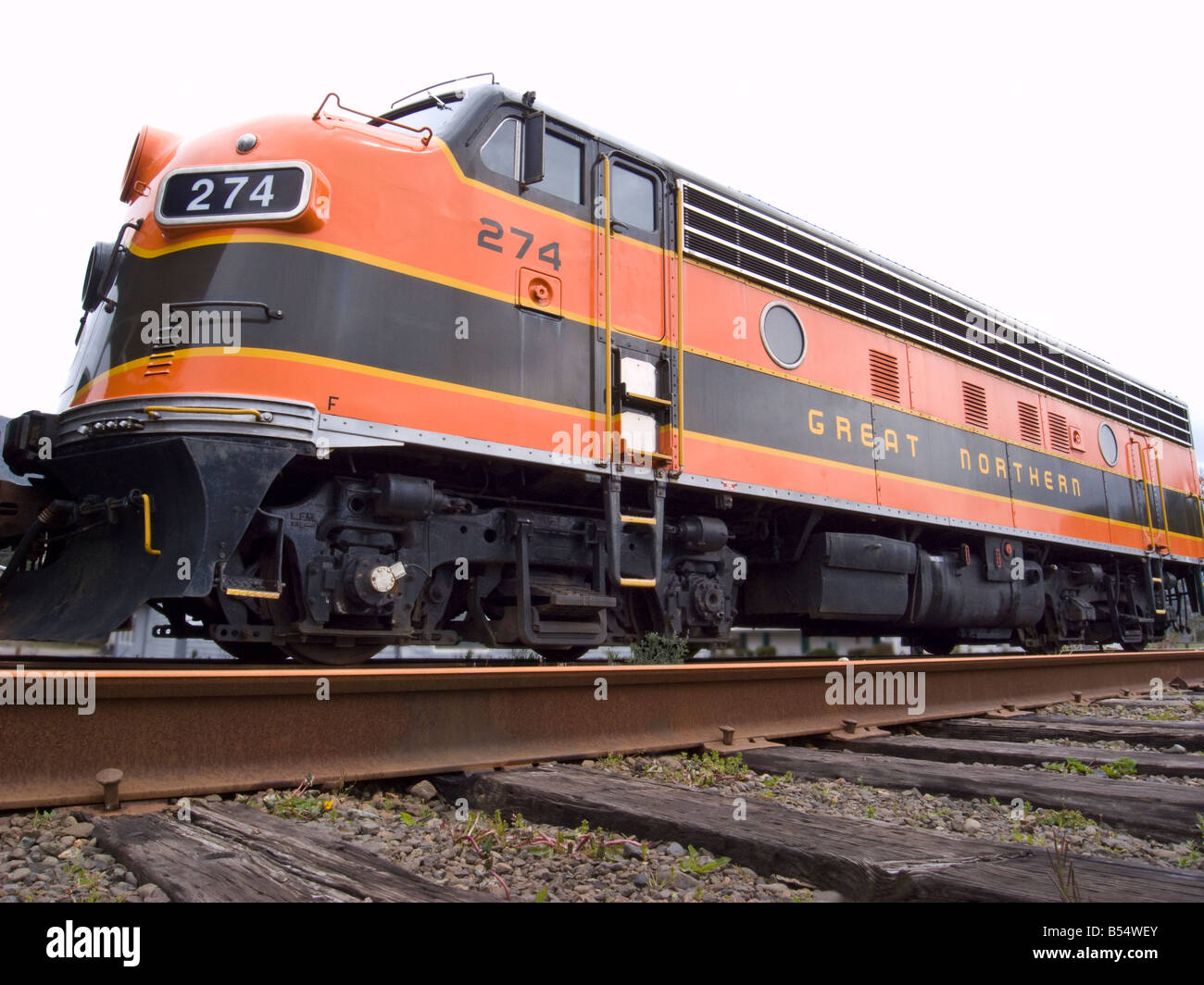 Low angle of diesel locomotive with train tracks in foreground Northern California USA Stock Photo