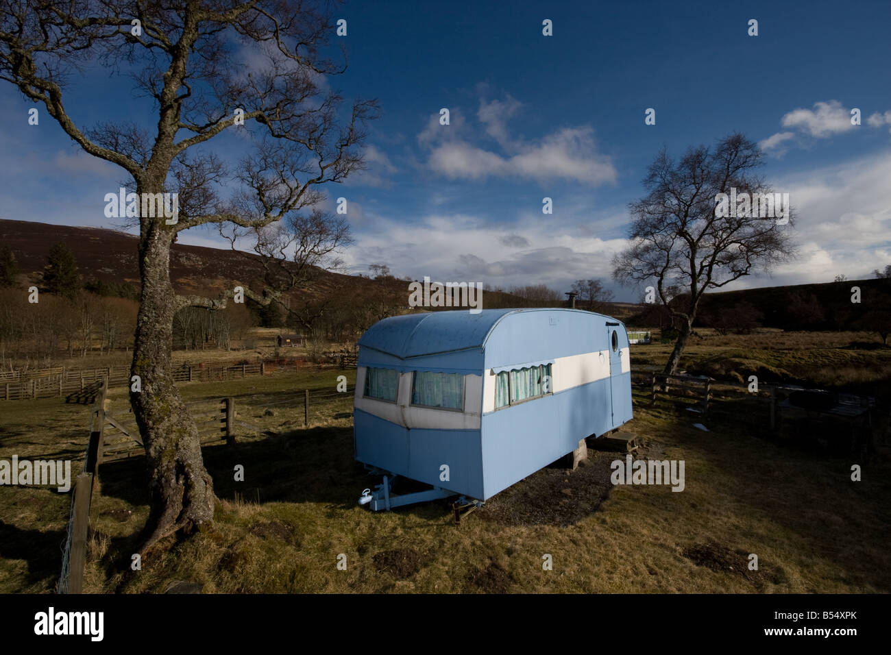 old fashioned blue caravan in a field Stock Photo Alamy