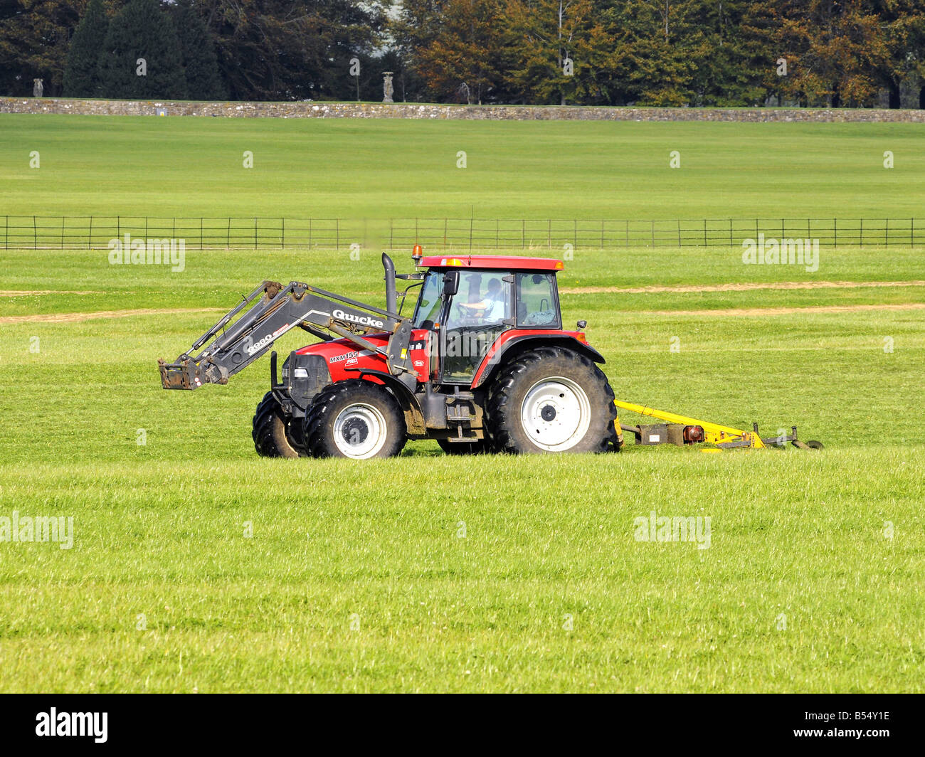 Red Farm tractor towing a large mowing machine Stock Photo Alamy