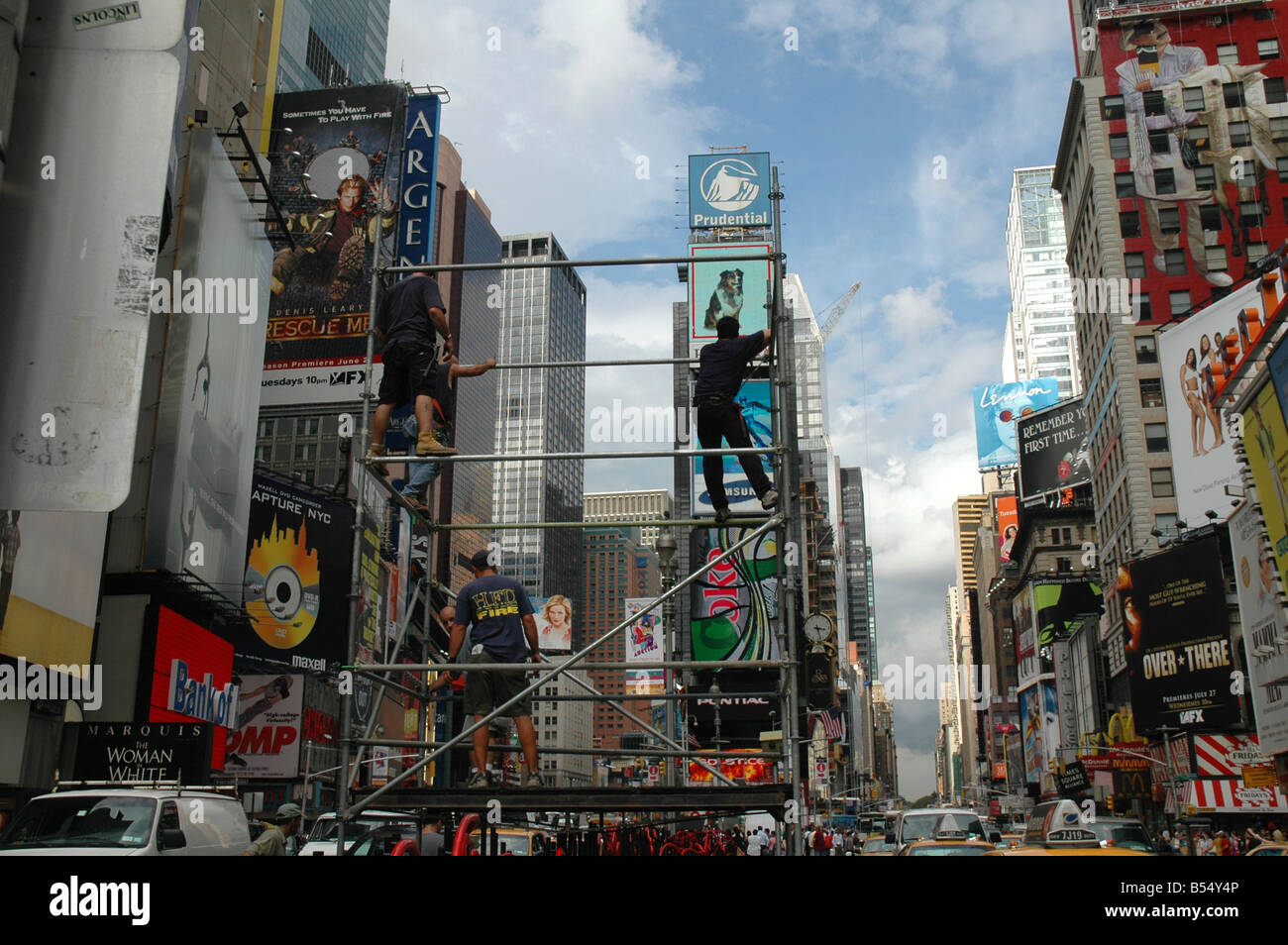 workmen on scaffold putting up new sign in middle of times square nyc Stock Photo