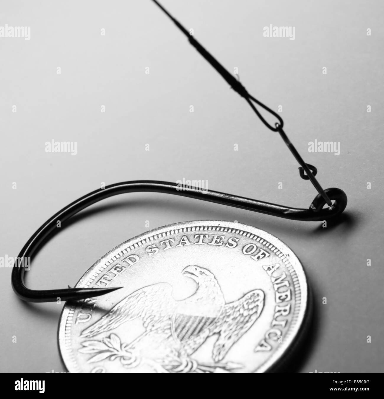 The close-up of old one dollar coin and fish hook Stock Photo