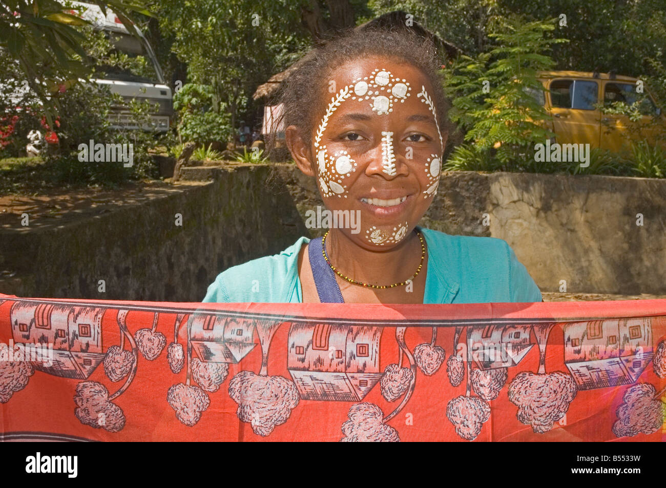 AFRICA MADAGASCAR Nosy Be young girl with decorated face selling cloth