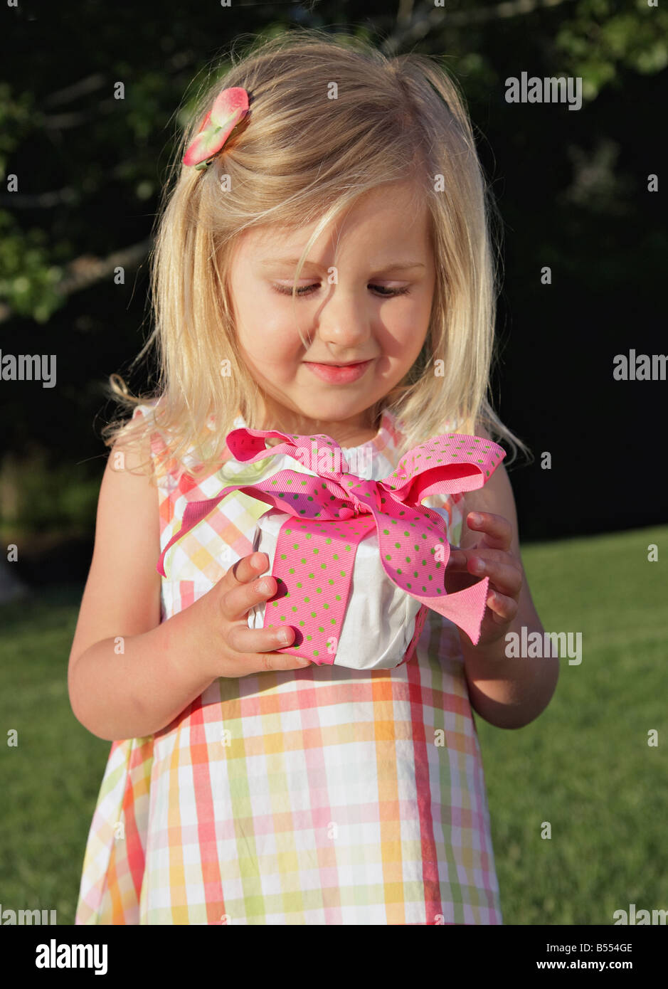 little girl happily holding a present Stock Photo - Alamy