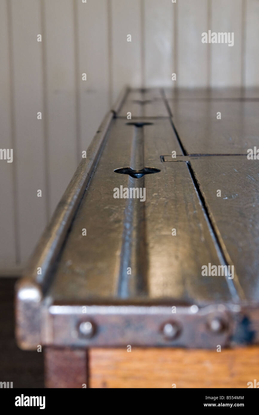 A colour portrait photograph of an old school desk ink well and pen