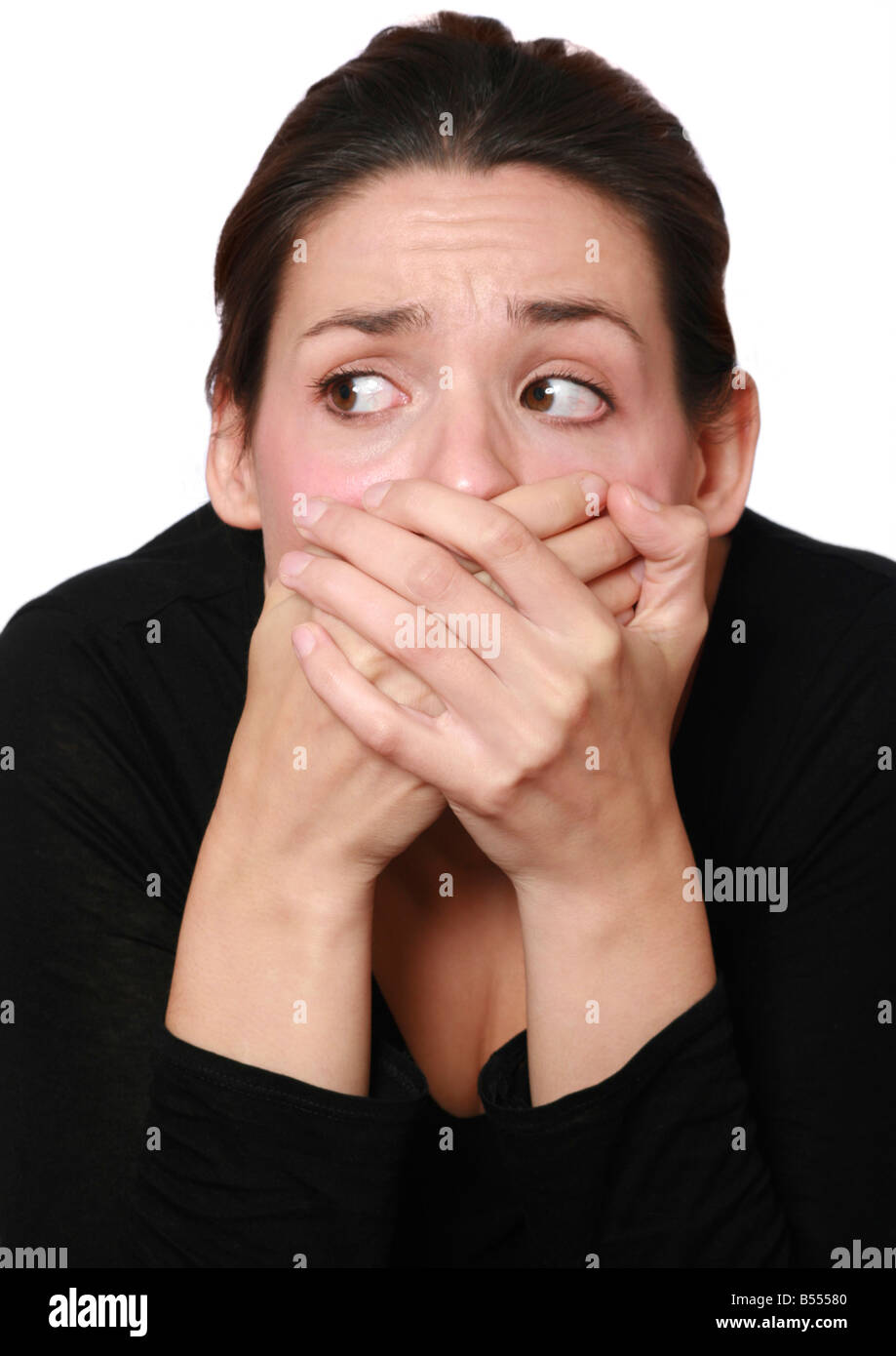 frightened woman covering her mouth with her hands Stock Photo