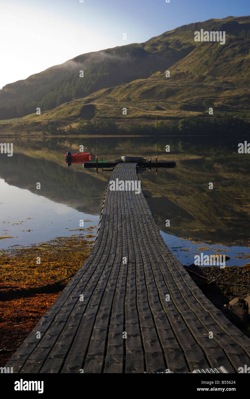 Looking down the jetty and the reflections in Loch Teacuis, Morvern, Scotland Stock Photo