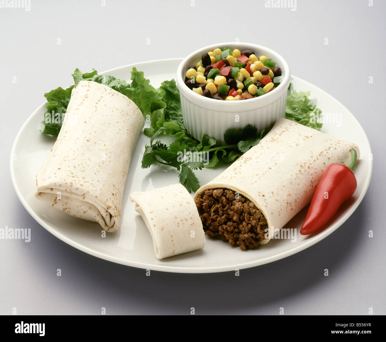 Ground beef burrito with green verde salsa. Stock Photo