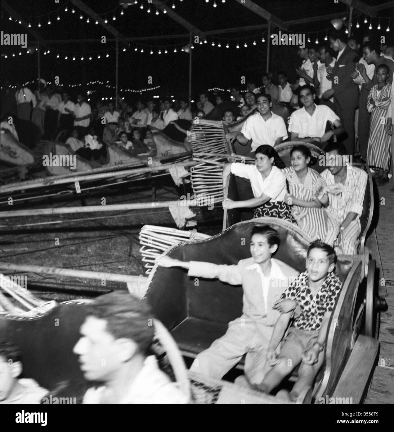 Egypt: Cairo funfair Egyptian families enjoying a night of fun at the fair on the outskirts of the city. The rotor ride was particular favourite. July 1953 D3826-002 Stock Photo