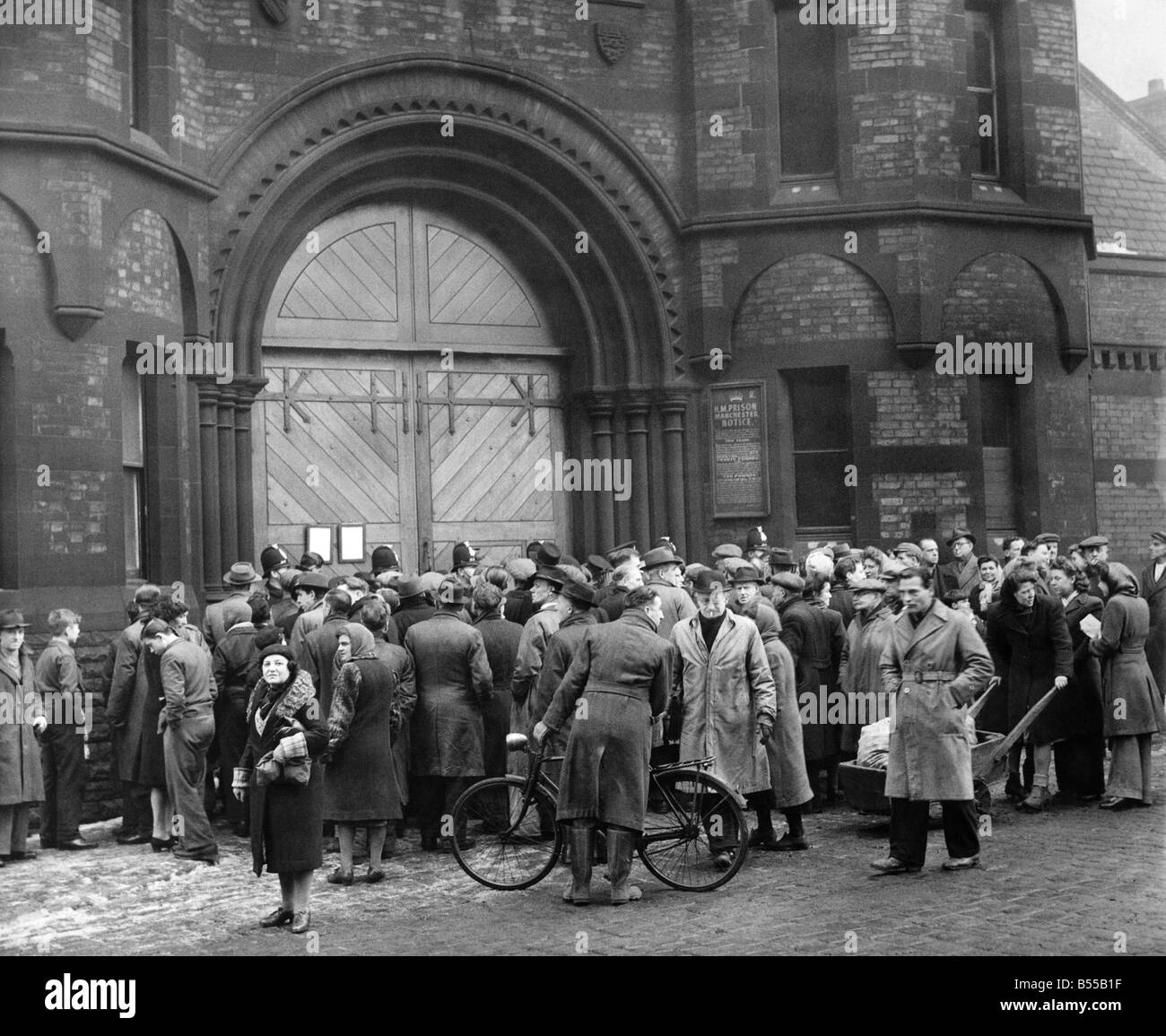 Walter Rowland execution at Strangeways prison. The crowd rush forward to read the death notice hung on the prison gate after the execution. While he had been awaiting execution, another man had confessed to the crime. A Home Office report dismissed this manÍs confession as false, but in 1951 the man attacked another woman and was found guilty but insane. February 1947 P012624 Stock Photo