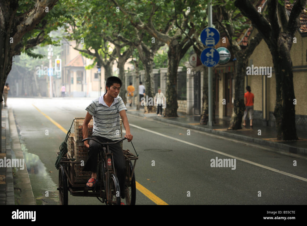 Rickshaw driving along the tree lined streets of the French Concession, Shanghai Stock Photo